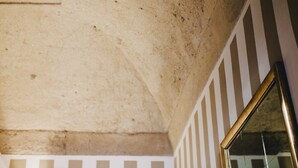 A textured ceiling with a visible crack, a striped wall, and a reflective surface. - Ma' Ca' - La Grigia (Praiano)