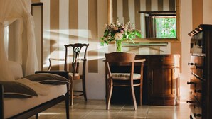 A room with a bed, two chairs, a wooden table with a vase of flowers, a mirror, and a dresser. - Ma' Ca' - La Grigia (Praiano)