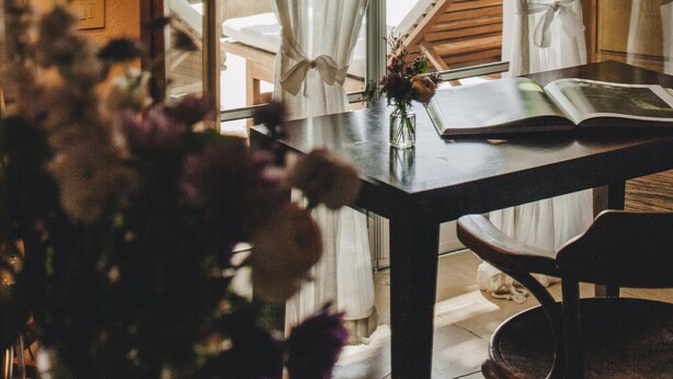 A room with a table, a lamp, a book, and a vase with flowers. - Ma' Ca' - New York (Praiano)