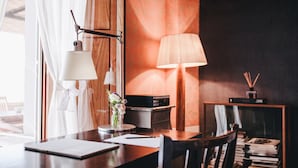 A room with a wooden desk, a lamp, a vase with flowers, and a bookshelf. - Ma' Ca' - Red Room (Praiano)