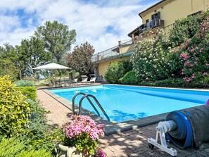 A swimming pool with a sunshade, lounge chairs, and a water pump. - Casa Vescovo by Interhome (Asti)