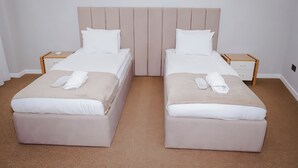 A double room with two beds, each with a wooden nightstand, a beige headboard, and white bedding. - Kichik Gala 98 (Baku)