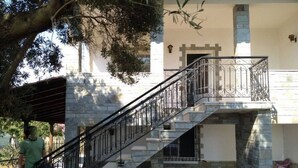 A two-story building with a stone staircase and metal railing. - Villa- Nea Kalikrateia - 2-bdroom Apartment (Nea Propontida)