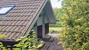 A house with a sloped roof, a skylight, and a small porch.