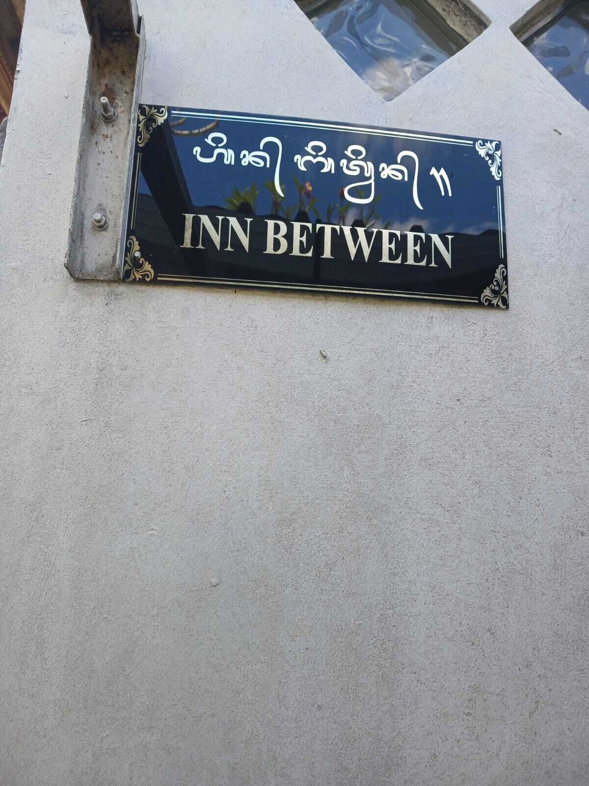 A sign for 'INN BETWEEN' with decorative elements and text.