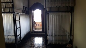 Un pasillo con piso de baldosas que conduce a una puerta con vista a un balcón.