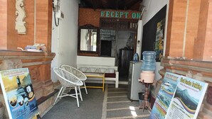 Zona de recepción con mostrador, dispensador de agua y carteles informativos.