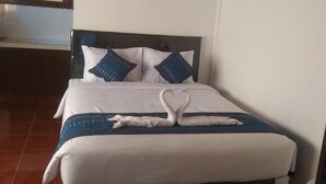Habitación de hotel con cama, almohadas y una decoración de toallas con forma de cisne.