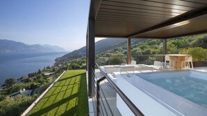 Un espace piscine extérieur moderne offrant une vue sur un lac et des montagnes.