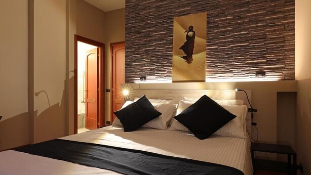 Ein Hotelzimmer mit einem Bett, einer Steinwand und einem Gemälde.