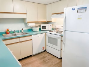 Eine Küche mit Spüle, Herd, Mikrowelle und Kühlschrank.