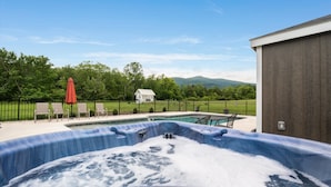 A hot tub with a view of a house and mountains in the background. - Afton Awaits (Afton)
