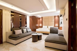 A modern living room with a sofa, ottoman, and a bed.