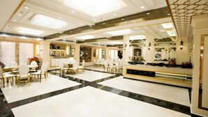A spacious hotel lobby with a central seating area, a reception desk, and a decorative ceiling. - TOS Residency Jublee Hills By OTABoostup (Hyderabad)