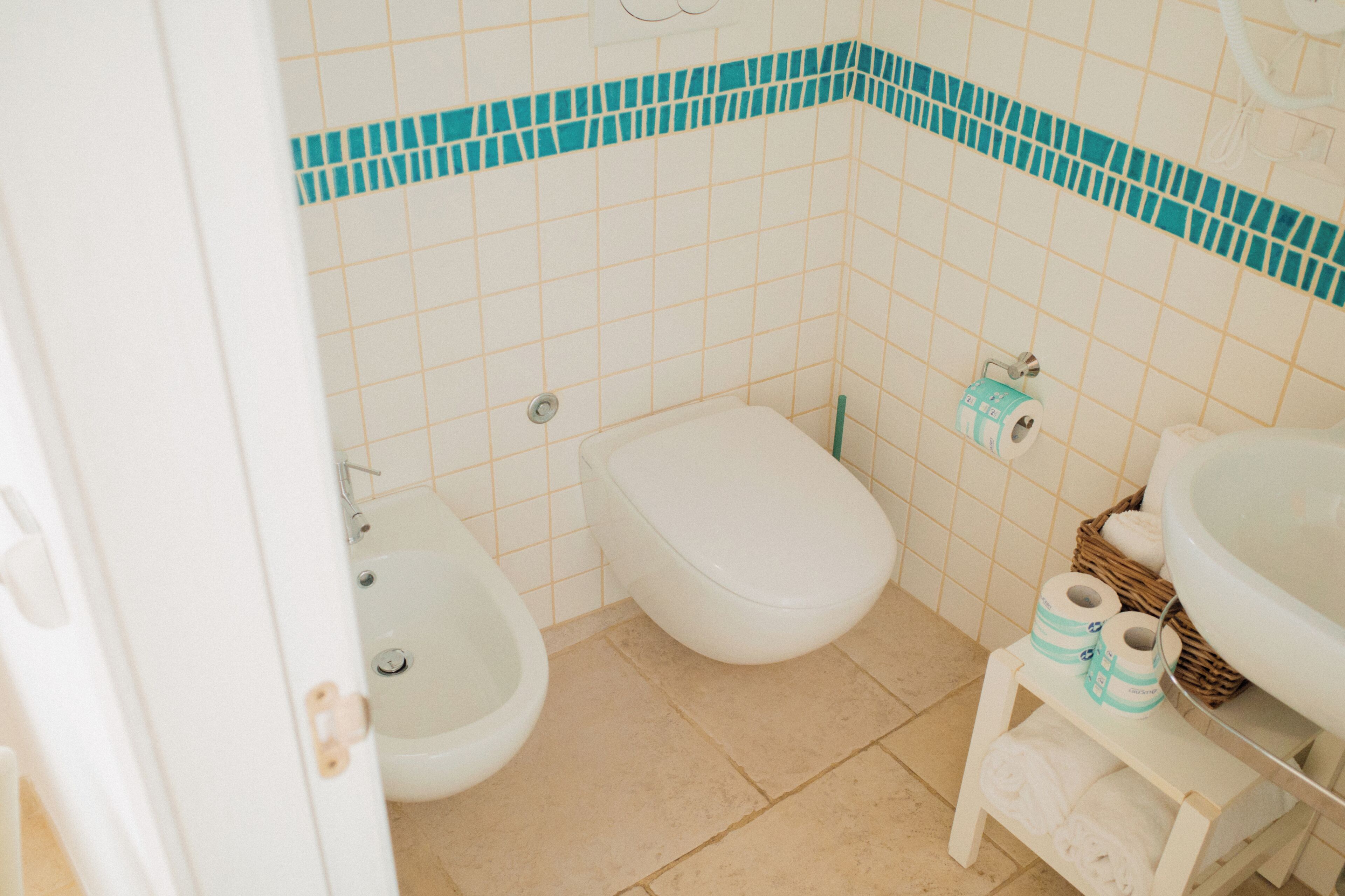 A bathroom with a toilet, bidet, and sink.
