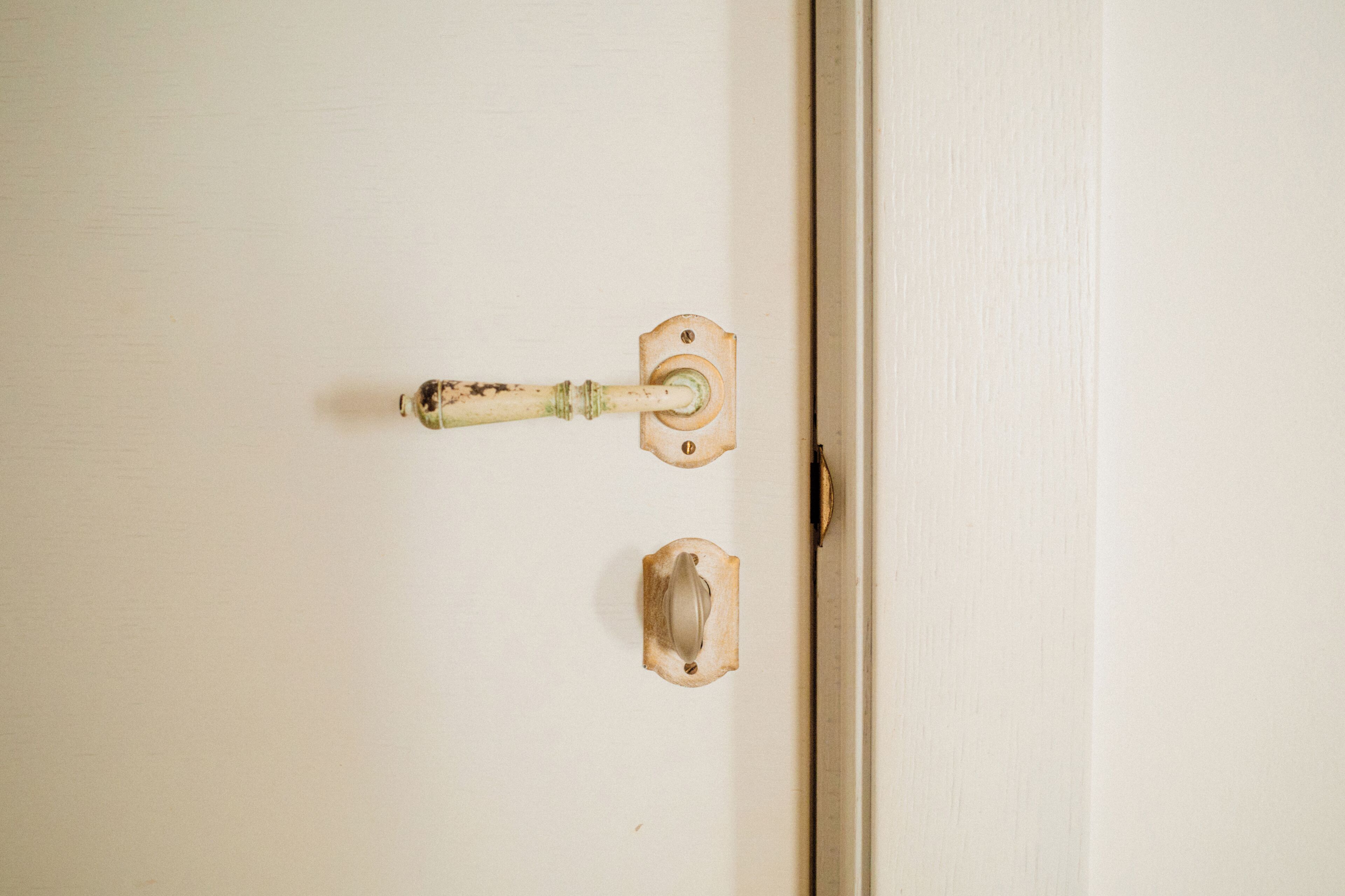 A white door with a brass doorknob and a keyhole.