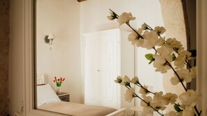 A bedroom with a bed, a nightstand, a lamp, a wardrobe, and a vase with flowers. - Dimora Rossella (Monopoli)