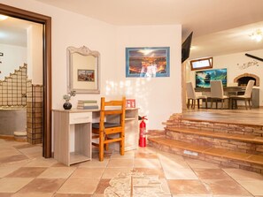 A hotel room with a desk, chair, a fire extinguisher, a TV, and a fireplace. - Vacation home Mamau by Interhome (Castelsardo)