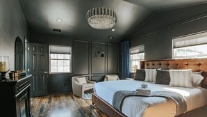 A modern bedroom with a large bed, a chandelier, and a view of the outdoors. - The Reserve at 151 (Afton)