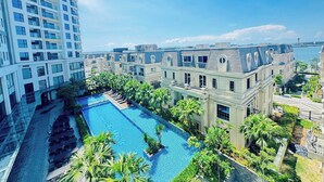 Un hotel moderno con piscina sul tetto, vegetazione lussureggiante e vista sul mare.