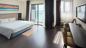 Una camera d'albergo moderna con un letto grande, una scrivania e vista sull'esterno.
