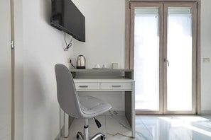 A modern office space with a desk, chair, television, and a sliding glass door. - GIOIA E RELAX DI ZR  (Rho)