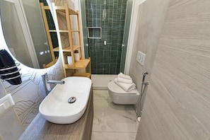 A bathroom with a white sink, a wooden shelf, a shower, and a toilet. - GIOIA E RELAX DI ZR  (Rho)