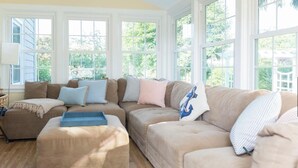 A living room with a sectional sofa, ottoman, and a blue tray.