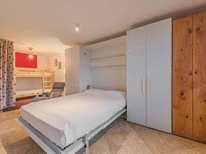A bedroom with a single bed, a bunk bed, a wardrobe, and a desk with a chair. - Ciasina Alpina by Interhome (Folgarida)