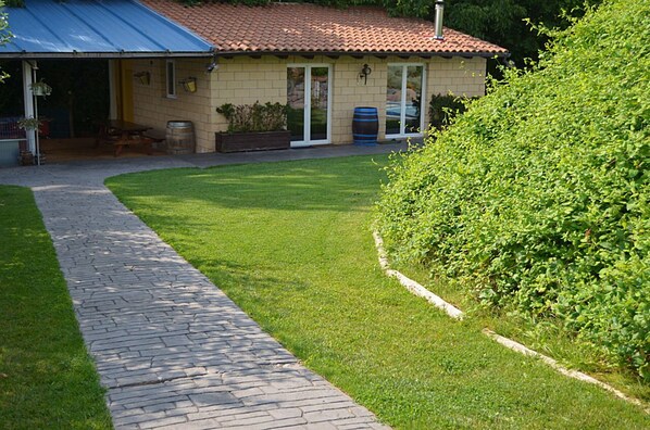 A house with a paved driveway, a lawn, and a metal roof.