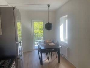A dining area with a table, chairs, a ceiling fan, and a view of greenery outside. - 3 Bedroom new Flat Close to Oslo Fjord (Bærum)