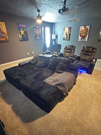 A room with a large bed, two reclining chairs, a ceiling projector, and various posters on the walls.. Modern ATL Stay 2BR 2BA Near Downtown W/ theater