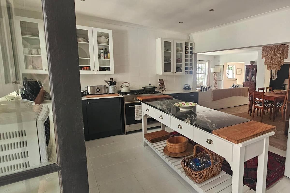Una cocina moderna con armarios blancos, una isla central y un refrigerador.