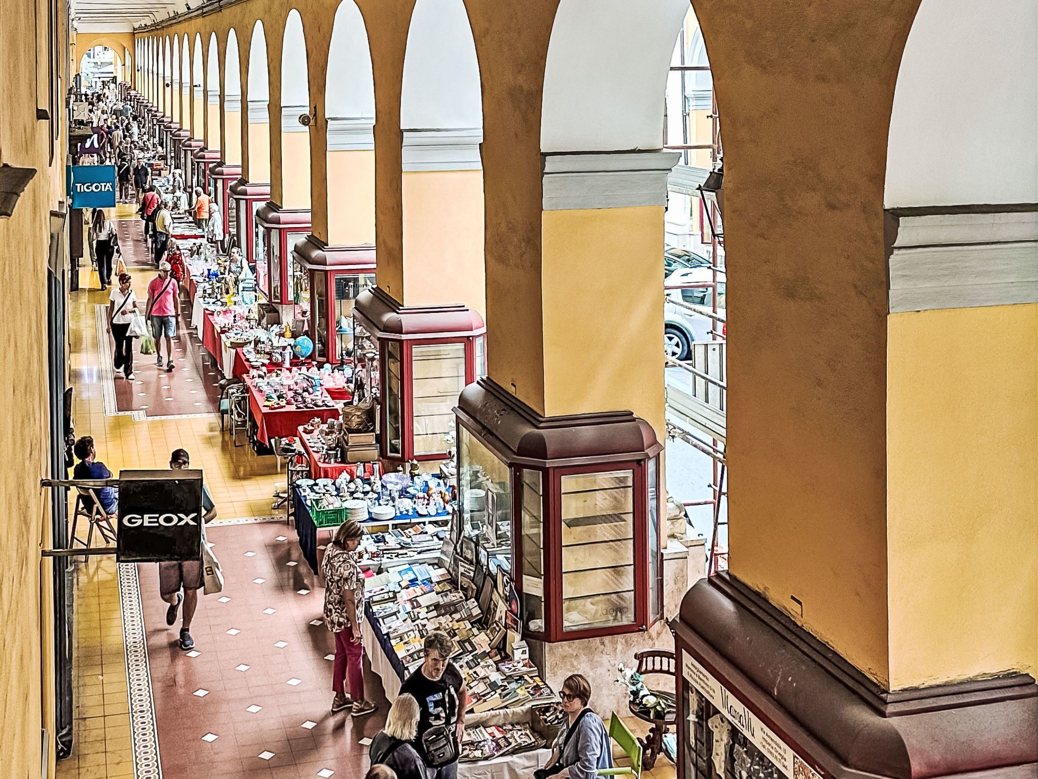 Un mercado cubierto con varios puestos y compradores.