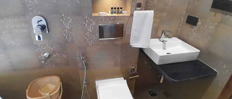 A bathroom with a white sink, a toilet, a shower, and a towel rack.