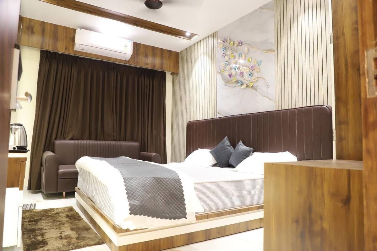 Un dormitorio moderno con cama, una silla, un escritorio y un equipo de aire acondicionado.