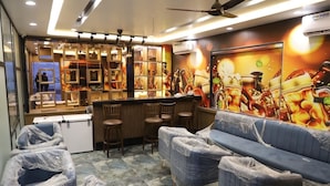 A restaurant with a bar area, cushioned seating, and a mural of food. - Moresta Ajmer Hotel with Rooftop Bar (Ajmer)