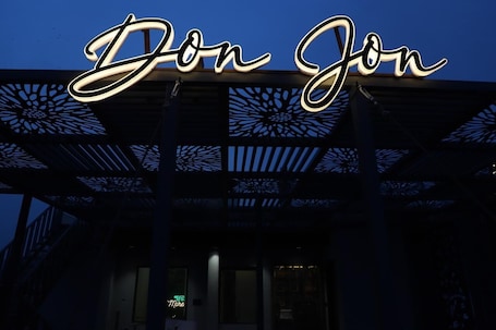 A building with a prominent illuminated sign reading 'Don Jon' and a decorative metal structure.. Moresta Ajmer Hotel with Rooftop Bar