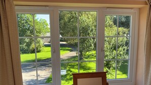 Ein Zimmer mit großem Fenster und Blick auf eine grüne Landschaft.