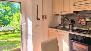 Una cucina con finestra, un fornello e mobili.