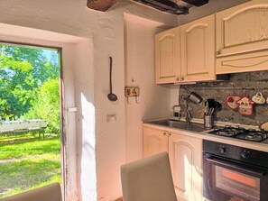 Eine Küche mit Fenster, Herd und Schränken.