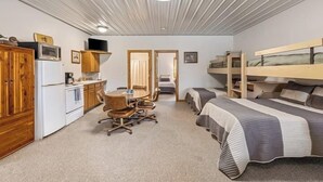 A bedroom with bunk beds, a desk, and a kitchenette. - The Goose Cabin | 5-Cabin Compound, Sleeps 30 (Decatur)