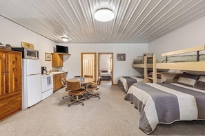 Un dormitorio con literas, un escritorio y una kitchenette.