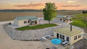 A waterfront property with a small building, a patio area, and a view of the water. - The Goose Cabin | 5-Cabin Compound, Sleeps 30 (Decatur)