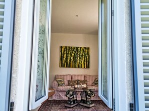 Ein Zimmer mit einer Couch, einem Tisch mit Dekoration und einem Gemälde an der Wand.