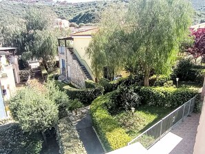 A residential area with a stone staircase leading to a building, surrounded by lush greenery and a pathway. - Sardinia Hillside Retreat – Apt 13, 2BR by Interhome (Valledoria)