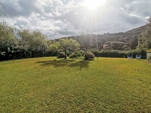 A grassy outdoor area with trees and a bench. - Sardinia Hillside Retreat – Apt 14 by Interhome (Valledoria)