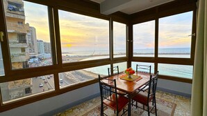 Ein Zimmer mit großem Fenster und Blick auf Stadt und Strand.