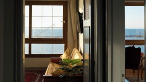 A room with a large window, a bed, a potted plant, and a view of the sea. - Vintage Modernized Sea View Apartment (Alexandria Governorate)