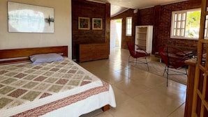 Un dormitorio con cama, cómoda de madera, una silla y un escritorio.